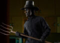The John Carver Sixth Scale Figure wears a burned mask and pilgrim hat while wielding a pitchfork