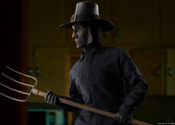 The John Carver Sixth Scale Figure wears a burned mask and pilgrim hat while wielding a pitchfork